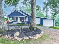 Charming blue bungalow with a covered front porch, rocking chairs, and an attached garage at 776 Green Dr, Canton, GA 30114