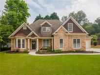 Charming home featuring a stone facade, manicured lawn, and a welcoming front entrance at 300 Brackin Trce, Grayson, GA 30017