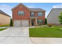 Charming two-story brick home with a well-manicured lawn and two-car garage in a desirable neighborhood at 3303 Hawthorn Farm Blvd, Loganville, GA 30052