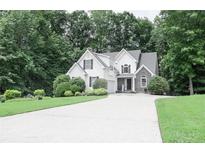 Charming two-story home with manicured lawn, complemented by lush, mature trees at 6985 Shane Ln, Cumming, GA 30028