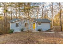 Charming ranch home with a cheerful yellow door and cozy front porch, nestled in a wooded lot at 2089 Quilt Ct, Lithonia, GA 30058
