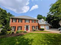 Beautiful two-story brick home with a lush green lawn and a two-car garage at 2903 Ashebrooke Ne Dr, Marietta, GA 30068