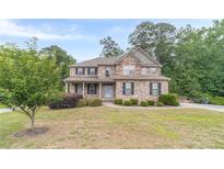 Charming two-story brick home with a well-manicured lawn, and a welcoming light blue front door at 1022 Nestling Dr, Lawrenceville, GA 30045