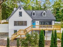 Charming two-story home with a bright blue door and a spacious wooden deck, nestled in a lush green landscape at 2552 Hunton Ne Ct, Marietta, GA 30068