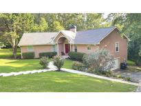 Charming single-Gathering home featuring a landscaped lawn, inviting walkway, and an attached two-car garage at 4221 Riverlake Way, Snellville, GA 30039