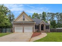 Charming two-story home boasts a brick and siding exterior, attached two-car garage, and a well-manicured front lawn at 232 Christian Cir, Carrollton, GA 30116