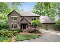 Brick home featuring a well-manicured lawn and a two-car garage at 5049 Lake Ter, Marietta, GA 30068