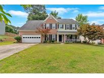 Charming two-story home featuring a manicured lawn and a welcoming front porch at 812 Roget Way, Lawrenceville, GA 30045