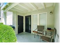 Outdoor patio with seating area including two chairs and a small table adjacent to the front door and greenery at 1150 Nw Collier Rd # K24, Atlanta, GA 30318