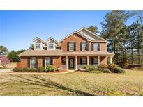 Charming two-story brick home with a welcoming front porch and well-maintained landscaping at 151 River Park Cir, Mcdonough, GA 30252