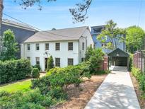 Charming two-story white home with lush landscaping and a convenient covered parking area at 67 Delmont Ne Dr, Atlanta, GA 30305