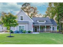Charming home with a beautiful lawn, complemented by flowering shrubs and a welcoming front porch with stone accents at 2980 Beards Rd, Buford, GA 30518