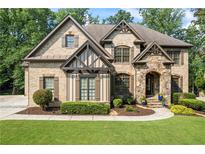Charming home with brick and stone facade, lush lawn and landscaping at 2517 Stone Manor Dr, Buford, GA 30519