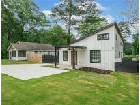 Charming home featuring a modern design, a well-manicured lawn, and a spacious concrete driveway at 2822 Waters Sw Rd, Atlanta, GA 30354