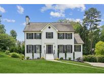 Charming two-story home features a white brick facade, black shutters, and a well-manicured lawn at 2907 Wickford Dr, Kennesaw, GA 30152