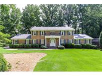 Charming brick home with a well-manicured lawn, lush landscaping, and a cozy second story balcony at 5287 Vernon Lake Dr, Atlanta, GA 30338