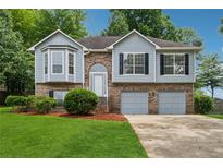 Charming two-story home boasts a brick and siding exterior and a well-maintained lawn at 12290 Greenmont Walk, Alpharetta, GA 30009