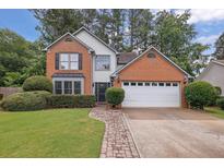 Charming two-story home with a brick and siding exterior, two-car garage and well-manicured front yard at 3202 Ivy Station Way, Duluth, GA 30096