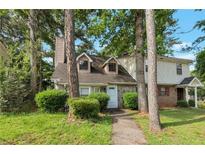 Charming townhouse with stone accents and mature trees surrounding the landscaped front yard at 134 Timber Creek Sw Ln, Marietta, GA 30060