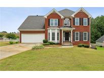 Charming two-story red brick home with a well-manicured lawn and attached two car garage at 630 Dana Pointe Ct, Lawrenceville, GA 30045