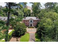 Stately red brick home with manicured lawn, mature trees, and circular driveway at 2883 Andrews Nw Dr, Atlanta, GA 30305