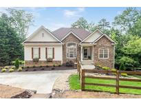 Charming home featuring stone accents, well-manicured landscaping, and a welcoming entrance at 1745 Habersham Marina Rd, Cumming, GA 30041