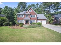 Charming two-story brick home with a manicured lawn and two-car garage at 4525 Cavallon Nw Way, Acworth, GA 30101