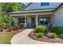 Charming home with a covered porch and beautifully landscaped front yard at 203 Belmont Park Dr, Canton, GA 30115
