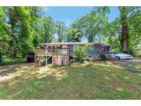 Charming single-story home featuring a wooden deck and lush greenery surrounding the property at 3220 Memorial Dr, Decatur, GA 30032