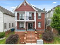Charming two-story home featuring double balconies, brick stairs, and lush landscaping at 121 Fulton Se Way, Atlanta, GA 30312