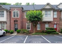 Brick townhome featuring a well maintained landscaped yard and assigned parking at 1215 Harris Commons Pl, Roswell, GA 30076