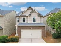 Charming home featuring a two-car garage, brick accents, and beautifully maintained landscaping at 503 Mill Ridge Rd, Woodstock, GA 30188