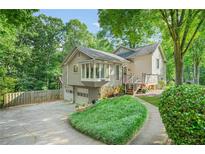 Charming multi-level home with a bay window, attached two-car garage, and lush landscaping at 2666 Peachtree Walk, Duluth, GA 30096