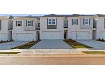Modern townhome exterior with white brick, gray shutters, and individual driveways at 333 Heavenly Hollow Pl, Mcdonough, GA 30253