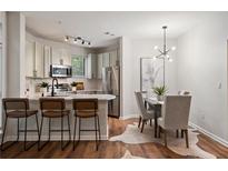 Bright kitchen and dining area with stainless steel appliances, bar seating and modern lighting at 821 Ralph Mcgill Ne Blvd # 2219, Atlanta, GA 30306