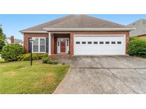 Charming one-story brick home featuring an attached two-car garage and manicured front lawn at 2260 Burlington Ln, Snellville, GA 30078