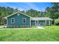 Charming one-story home with inviting front porch and a well-manicured lawn in a wooded area at 2969 White Ne Rd, Conyers, GA 30012