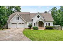 Charming two-story home features a well-manicured lawn, white siding, and an attached two-car garage at 326 Seldom Seen Trl, Canton, GA 30115