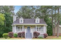 Charming home with a cozy front porch, dormer windows, and a well-maintained lawn with mature trees at 19 Willowbrook Ct, Acworth, GA 30101