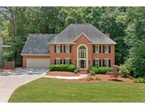 Charming two-story brick home featuring a well-manicured lawn and lush landscaping at 3638 Sope Creek Farm Se, Marietta, GA 30067