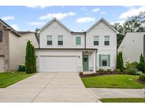 Charming two-story home featuring white siding, green shutters and door, plus a well-manicured lawn at 149 Archie Way, Woodstock, GA 30188