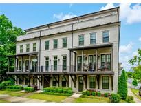 Charming townhome with a brick facade, complemented by stylish balconies and lush green landscaping at 2063 Wheaton Way, Sandy Springs, GA 30328