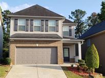 Charming two-story home with a two-car garage, brick accents, and manicured landscaping at 3179 Woodward Down Trl, Buford, GA 30519