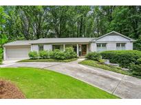 Charming one-story home features a brick facade, attached garage, and a beautifully landscaped front yard at 80 Maryeanna Dr, Sandy Springs, GA 30342