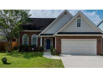 Charming brick home featuring a well-manicured lawn, attached two car garage and inviting blue front door at 2163 Berryhill Se Cir, Smyrna, GA 30082