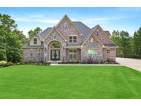 Beautiful two-story brick home with manicured lawn and arched entryway at 7519 Waterview Cv, Douglasville, GA 30135