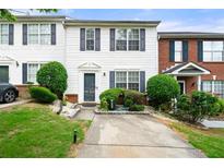 Inviting two-story townhome with charming curb appeal and neat landscaping at 1320 Revelstoke Cv, Riverdale, GA 30296
