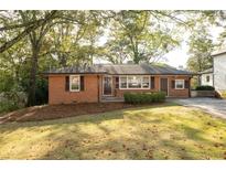 Charming brick home with a well-maintained lawn and mature trees, creating a welcoming curb appeal at 6332 N Hampton N Dr, Atlanta, GA 30328