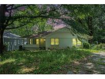 Charming one-story home with a covered front porch and a mature, tree-filled front yard at 1212 Eastridge Sw Rd, Atlanta, GA 30311
