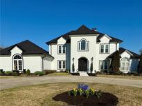 Stunning two-story white home with a black roof, arched entry, and circular driveway at 3011 Flat Shoals Sw Rd, Conyers, GA 30094